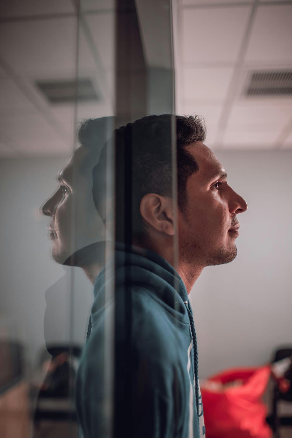 Fotografía de hombre observando a través de un cristal que representa reflexión personal, claridad interior y conciencia en procesos de transformación